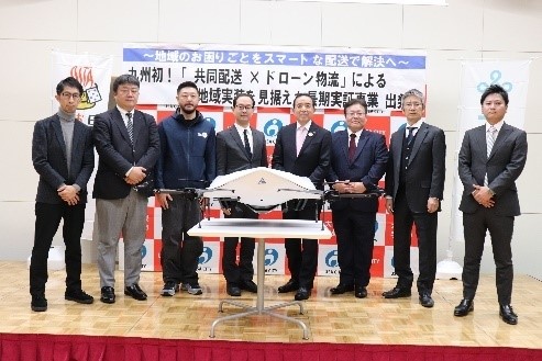 (向かって左から3番目から左順に) NEXTDELIVER取締役 青木孝人、大分県商工観光労働部長 利光秀方、宇佐市長 是永修治、中津急行常務取締役 藤井秀男 ほか本事業連携事業者代表の皆様