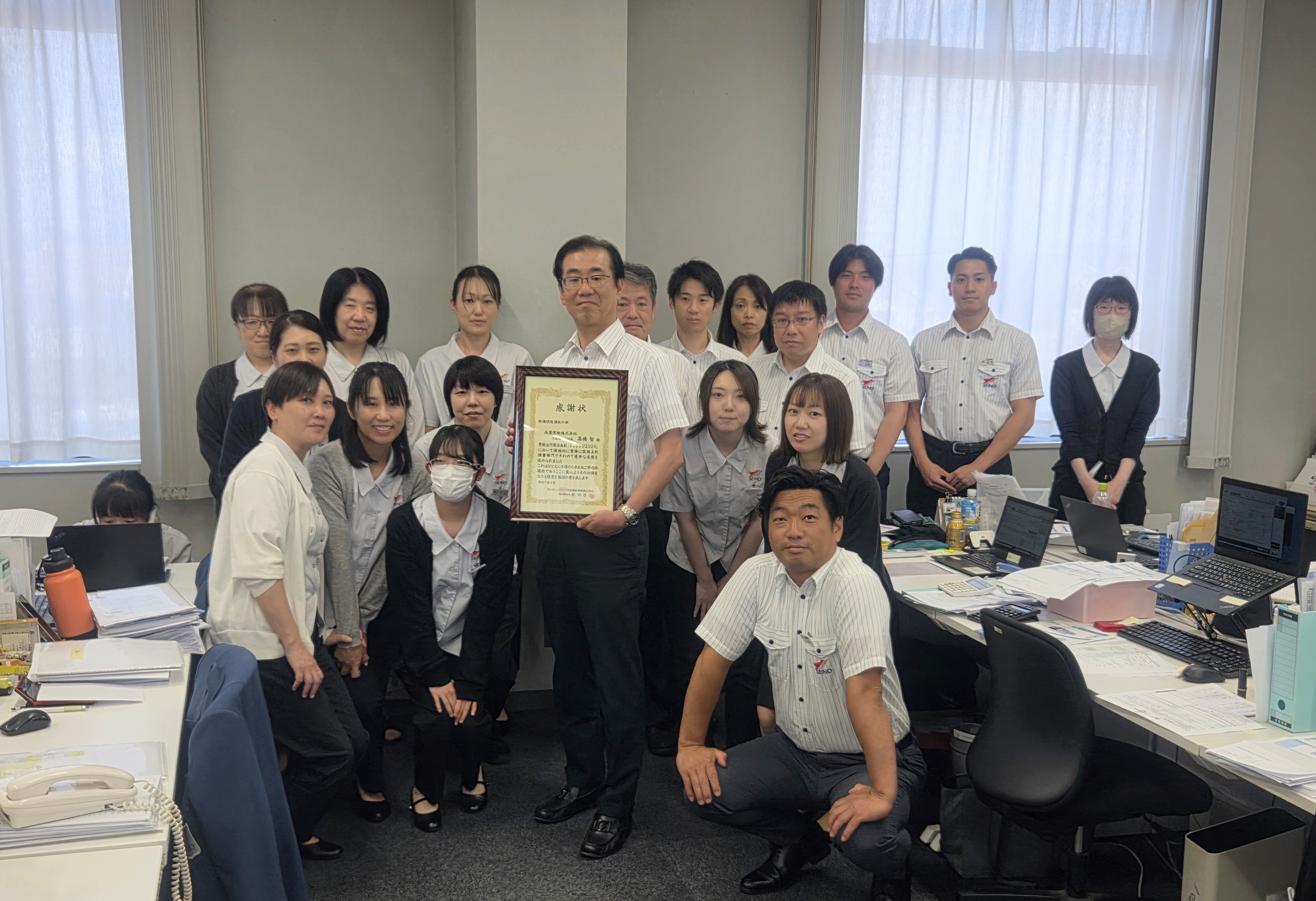 髙橋社長と激励を受けた保険課との記念写真